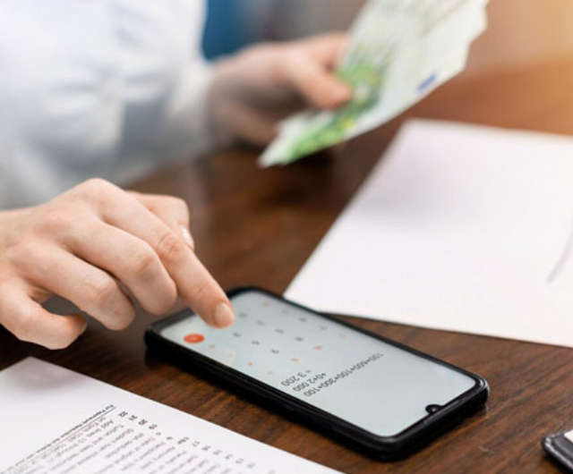 Person using smartphone to manage finances with cash in hand, representing instant funding payday loans.