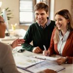 Couple consulting with a loan advisor, discussing personal loan options in a welcoming office environment.