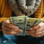 Person holding cash, symbolizing same-day cash advance options in California, highlighting urgency and financial support.