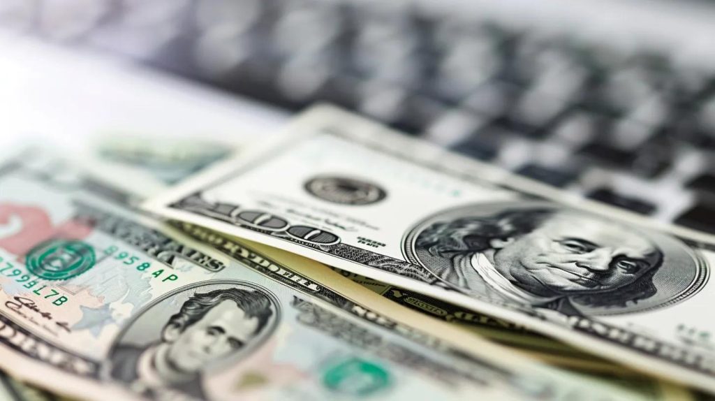 Close-up of U.S. dollar bills on a laptop keyboard, symbolizing fast online payday loans and instant cash access in California.